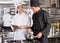 Male Chef Assisting Colleague In Preparing Food