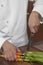 Male Chef Cutting Carrots On Wooden Board