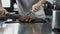 Male chef cutting steak at kitchen restaurant. Closeup chef hands cutting meat