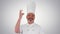 Male chef making real jam gesture to camera on gradient background.