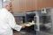 Male Chef Placing Baking Tray In Oven