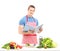 A male chef reading a cookbook while preparing a salad