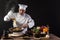 Male chef in white uniform pouring boiled spaghetti into pan wok for cooking pasta with vegetables