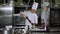 A male chef in a works in a restaurant kitchen, salt something in a metal bowl.