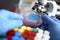 Male chemist hand in blue protective gloves hold petri dish closeup