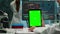 Male chemist scientist holding green mock-up screen tablet