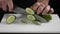 Male chief cook chopping vegetables, Slicing cucumber on white board. Close up. Man on kitchen cooking natural and