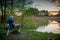 male child sitting on wooden bench near lake