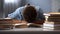 Male child sleeping on table tired of reading books, doing lot of homework