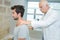 Male chiropractor doing neck adjustment in rehabilitation center