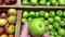 Male chooses fresh organic green apples in supermarket.