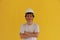 Male civil engineer with white helmet and wear white T-shirt on yellow background. Standing and cross one`s arm