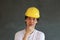 Male civil engineer with yellow helmet and wear white T-shirt on dark grey background. Standing and expressing thoughts