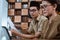 male civil servants in uniform sit holding worksheets next to female civil servants