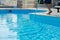 Male cleaning outdoor swimming pool with underwater vacuum tube