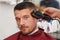 Male client getting haircut by hairdresser.