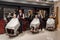 Male clients sitting in hairdresser chairs covered with haircut.