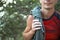 A male climber of Caucasian appearance with a coiled rope on his shoulder. Hand in white magnesia. Red sports Jersey, extreme spor