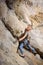 Male climber climbing big boulder in nature with rope