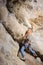 Male climber climbing big boulder in nature with rope