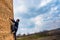 A male climber climbs a brick water tower