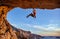 Male climber gripping on handhold while climbing in cave.