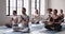 Male coach and multi-ethnic people meditating seated in lotus position