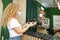 Male coffee shop worker giving ready order to the client wearing face mask