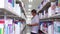 Male college student reads book in library aisle