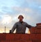 Male construction worker at a construction site brick building holding tool smiling cheerful