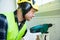 Male construction worker in hard hat drilling concrete wall