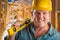 Male Contractor in Hard Hat Holding Level and Pencil At Worksite