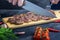 A male cook cuts a steak into portions. Fresh meat is medium rare