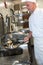 Male cook making chicken in frying pan