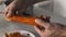 Male cook peeling carrots for salad.