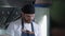 Male cook in uniform prepares food for visitors in a fast food cafe against a grill background