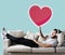 Male on a couch holding a heart emoticon