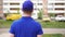 A male courier delivery service is walking down the street in a medical mask