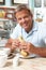 Male Customer Enjoying Sandwich And Coffee In Cafe