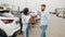 Male customer having conversation with competent saleswoman while choosing car at showroom. Man and woman standing