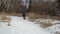 Male cyclist with a backpack is riding a touring bike on a snowy trail