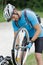Male cyclist fixing bicycle wheel