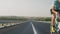 A male cyclist rides on a new highway, leaving the frame against the background of a long road. A guy on a road bike