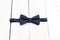 Male dark blue bow tie on a wooden background. Elements of style