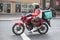 Male delivery rider on motorbike with Deliveroo bag