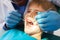 Male dentist examining boy teeth