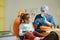 a male dentist teaches a little girl how to brush her teeth properly with a toothbrush.