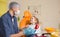 a male dentist teaches a little girl how to brush her teeth properly with a toothbrush.