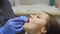 Male dentist treating teeth to young woman patient in clinic.