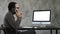 Male Designer Working At Computer In Contemporary Office. He talks on the phone and looking on what is on the screen